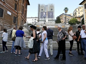 People walk near a barrier that closes the entrance to the Spanish Steps in Rome, Italy October 7, 2015. Restoration work started on Wednesday at Rome's Spanish Steps, making the scene of one of cinema's most famous ice cream breaks the latest Italian landmark to undergo privately-funded repairs. REUTERS/Alessandro Bianchi