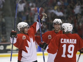Team Canada defenceman Logan Pyett (left) and teammates.