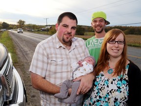 LUKE HENDRY/THE INTELLIGENCER
Holly Smith and Roy Walker hold their son, Emmerson Roy Walker, on Foxboro-Stirling Road in Quinte West. Behind them is Matt Mitchell, who helped the couple to deliver Emmerson Sept. 26 in their truck.