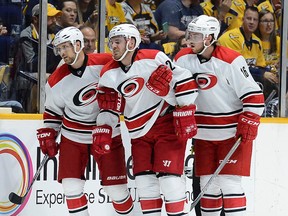 Carolina Hurricanes defenseman James Wisniewski, center, is helped off the ice by John-Michael Liles, left, and  Elias Lindholm after being injured in the first period of an NHL hockey game against the Nashville Predators, Thursday, Oct. 8, 2015, in Nashville, Tenn. (AP Photo/Mark Zaleski)