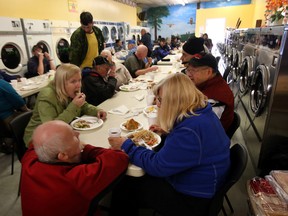 Guests enjoy their meals during the 22nd annual Thanksgiving Dinner at the Millbourne Laundromat in Edmonton, Alberta on Monday,Oct. 13, 2014. The dinner is serve by volunteers and members of the South East Rotary Club.  Perry Mah/Edmonton Sun
