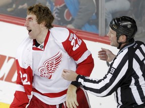 A bloodied Mike Commodore of the Detroit Red Wings skates away after a scrap with Tim Jackman of the Calgary Flames during NHL action in Calgary on Jan. 31, 2012. (Lyle Aspinall/Postmedia Network/Files)