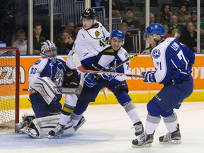 London Knights' Max Jones tangles with Sudbury Wolves defenceman Kyle Capobianco in front of Wolves netminder Troy Timpano during OHL action in London, Ont., on Friday night.