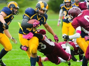 Braeden Sinclair of the St. Thomas St. Joseph Rams is tackled by Chase McGee of the John Paul II Jaguars during a Thames Valley senior high school football game Friday at John Paul II. The Rams won 29-15. (MIKE HENSEN, The London Free Press)