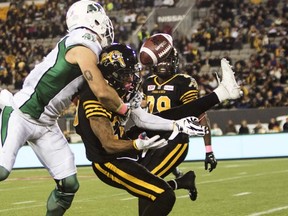 Tiger-Cats defensive back Emanuel Davis (right) misses an interception opportunity against Roughriders receiver Rob Bagg (left) during second half CFL action in Hamilton, Ont., on Friday, Oct. 9, 2015. (Aaron Lynett/Reuters)
