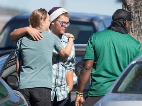 Umpqua Community College shooting survivor Mathew Downing (C) is greeted as he arrives on campus near Snyder Hall on October 5, 2015 in Roseburg, Oregon. Downing was given a package by gunman Chris Harper-Mercer and told he was the "lucky one" who would survive to deliver the package to authorities.  Scott Olson/Getty Images/AFP