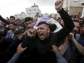 Mourners carry the body of Palestinian Mohammed Jabari, who stabbed an Israeli policeman before being shot dead on Friday, in the West Bank city of Hebron October 10, 2015. REUTERS/Mussa Qawasma