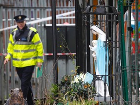 Flowers are left at the entrance of a travelers' site, the scene of a fire in Carrickmines, Dublin, Ireland, Saturday, Oct. 10, 2015.  Police say nine people, including an infant, have died in a fire at a mobile home camp for Ireland’s native Gypsies. Detectives say they have yet to establish a cause for Saturday’s fire at a Dublin council-run housing site for Irish Gypsies, who in Ireland are known as 'travelers.'  (AP Photo/Peter Morrison)