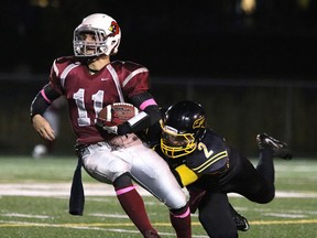 Sean Antonioni of the Lively Hawks tries to take down St. Charles Cardinals Nathan Scruton during senior boys high school football action from James Jerome Field in Sudbury, Ont. on Friday October 9, 2015. The Cardinals won 42-12.
