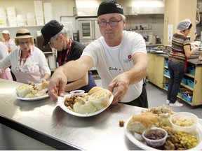 Volunteers serve up a meal at the annual Thanksgiving dinner at Siloam Mission in 2014. (File)