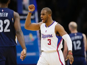 In this April 11, 2015, file photo, Los Angeles Clippers' Chris Paul, center, celebrates between Memphis Grizzlies' Jeff Green, left, and Nick Calathes after scoring during the second half of an NBA basketball game in Los Angeles. (AP Photo/Danny Moloshok)