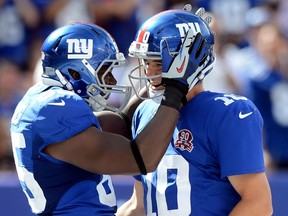 Tight end Daniel Fells #85 celebrates a third quarter touchdown with quarterback Eli Manning #10 of the New York Giants against the Arizona Cardinals during a game at MetLife Stadium on September 14, 2014 in East Rutherford, New Jersey.   Ron Antonelli/Getty Images/AFP
