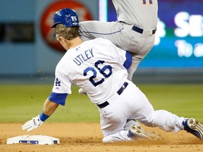 Ruben Tejada #11 of the New York Mets is hit by a slide by Chase Utley #26 of the Los Angeles Dodgers in the seventh inning in an attempt to turn a double play in game two of the National League Division Series at Dodger Stadium on October 10, 2015 in Los Angeles, California.   Sean M. Haffey/Getty Images/AFP
