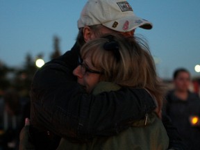 Melanie Alix holds is comforted by a supporter at a vigil on Oct. 11, 2015, at the spot where her son, Dylan Koshman, was last seen. Koshman, then 21, was last seen at the corner of 34 Avenue and Calgary Trail on Oct. 11, 2008 and has not been seen or heard from since.