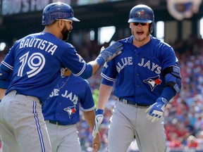 Toronto Blue Jays third baseman Josh Donaldson, right, celebrates his two-run home run with right fielder Jose Bautista (19) during the first inning in Game 4 of baseball's American League Division Series against the Texas Rangers, Monday, Oct. 12, 2015, in Arlington, Texas. (AP Photo/LM Otero)