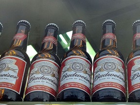 Bottles of Budweiser beer in a shop window in London, Tuesday, Oct. 13, 2015. The world's top two beer makers agreed Tuesday to join forces to create a company that would control nearly a third of the global market. AB InBev's brands include Budweiser, Stella Artois and Corona, while SABMiller produces Peroni and Grolsch. (AP Photo/Kirsty Wigglesworth)
