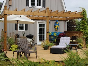 The new deck area includes a pergola, a patio table, a separate conversation area for guests, a spot for a comfortable lounger and a reading chair.