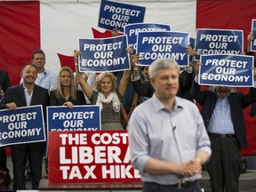 Supporters hold up signs as Canada's Prime Minister and Conservative leader Stephen Harper speaks during a campaign rally at William F. White International Inc, a stage lighting equipment supplier in Etobicoke, a suburb of Toronto, October 13, 2015.  Canadians will go to the polls for a federal election on October 19.   REUTERS/Mark Blinch