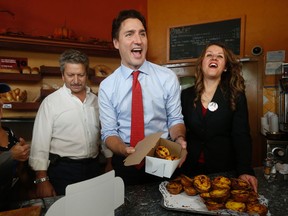 Liberal Leader Justin Trudeau and Davenport candidate Julie Dzerowicz (R) along with Helder Costa (L), owner of Caldense Bakery on Symington, serve up custard tarts on Tuesday October 13, 2015 in Toronto. (Jack Boland/Toronto Sun)