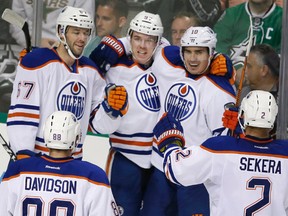Oilers centre Connor McDavid celebrates his first NHL goal with teammates during the second period of Tuesday's game against the Stars in Dallas. (USA TODAY SPORTS)
