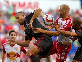 Toronto FC midfielder Benoit Cheyrou (8) and New York Red Bulls forward Mike Grella (13) and Toronto FC defender Justin Morrow (2) battle for the ball during the first half at Red Bull Arena. Noah K. Murray-USA TODAY Sports