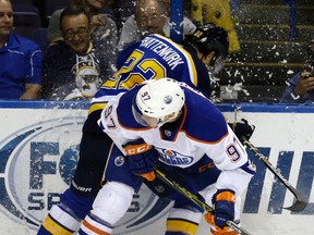 Connor McDavid takes Blues defenceman Kevin Shattenkirk into the boards in the hard-fought season opening loss in St. Louis. (AP Photo)