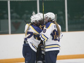 Laurentian Voyageurs women's hockey players mob team co-captain Ellery Veerman after she scored the tying goal late in the third period Saturday against Waterloo at Gerry McCrory Countryside Arena.