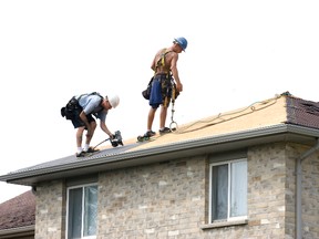 Roofers Jeff Morris (left) and Daryl Horne work for Mustang Exteriors Inc. in London.  (DEREK RUTTAN, The London Free Press)