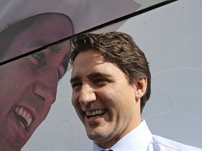 Liberal leader Justin Trudeau laughs in front of his campaign bus during a stop in Toronto, Ontario Oct. 13, 2015.  REUTERS/Chris Wattie