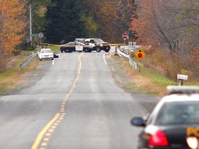 Ontario Provincial Police are seen inspecting an area of County Road 20 in North Grenville, near Bishops Mills, where police say a body was discovered Wednesday evening. MATT DAY/OTTAWA SUN