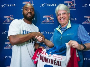 Newly-acquired Montreal Alouettes quarterback Kevin Glenn poses for the cameras with general manager and head coach Jim Popp following a news conference in Montreal, Wednesday, October 14, 2015. (THE CANADIAN PRESS/Graham Hughes)