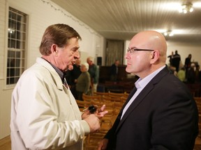 Amherst Island farmer Bruce Caughey, left, talks to Ontario Transportation Minister Steven Del Duca at a meeting about the area's ferry situation in Marysville on Wednesday.(Elliot Ferguson/The Whig-Standard)