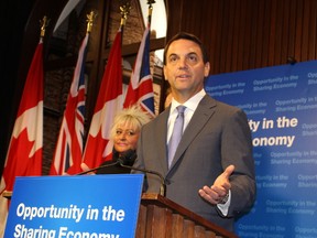 Tim Hudak, flanked by Uber driver Ester Nerling at a Queen's Park media conference, says his private member's bill would facilitate the sharing economy, on Thursday October 15 2015. (Antonella Artuso/Toronto Sun)
