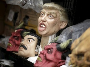 Masks of Republican presidential candidate Donald Trump (C) and Joaquin "El Chapo" Guzman (2nd L) are seen at Grupo Rev in the Mexican city of Cuernavaca near Mexico City, October 14, 2015. The hunt for Mexico's most-wanted kingpin Joaquin "El Chapo" Guzman may get a little harder this Halloween with a Mexican company capitalising on the druglord's brazen escape by releasing a costume in time for the scary season. Grupo Rev in the Mexican city of Cuernavaca have begun producing masks in Guzman's likeness. With the company exporting to some 30 countries globally, the kingpin's costume complete with prison costume is set to be a hot seller. Picture taken October 14, 2015. REUTERS/Henry Romero