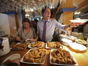 Liberal leader Justin Trudeau and his wife Sophie serve baklava during a campaign stop at a restaurant in Laval, Quebec, October 15, 2015. (REUTERS/Chris Wattie)