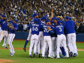 The Toronto Blue Jays rush the field after they defeat the Texas Rangers during the ALDS game 5 at the Rogers Centre in Toronto, Ont. on Wednesday October 14, 2015. Dave Abel/Toronto Sun/Postmedia Network