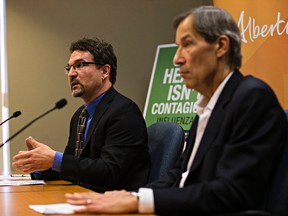 AHS deputy chief medical officer of health Dr. Martin Lavoie, left, and senior medical officer of health Dr. Gerry Predy, right, speak about the influenza vaccine during a press conference at the ATB Place North Tower in Edmonton, Alta., on Thursday, Oct. 15, 2015. Codie McLachlan/Edmonton Sun
