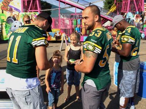 Ryan King, centre, joins teammates in signing autographs for fans during training camp in Spruce Grove this summer. (Ian Kucerak, Edmonton Sun)