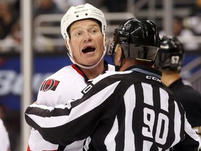 Oct 15, 2015; Pittsburgh, PA, USA; Ottawa Senators right wing Chris Neil (left) reacts while being restrained by linesman Andy McElman (90) against the Pittsburgh Penguins during the second period at the CONSOL Energy Center. Mandatory Credit: Charles LeClaire-USA TODAY Sports