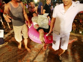 People carry an injured victim from an accidental explosion during a music concert at the Formosa Water Park in New Taipei City, Taiwan, June 27, 2015. (REUTERS/Chen Bo)