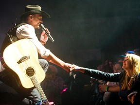 Paul Brandt greets a fan, Maggie Haley of London who was in the front row next to the stage as Brandt performed at Budweiser Gardens in London, Ont. on Thursday October 15, 2015.  Mike Hensen/The London Free Press/Postmedia Network