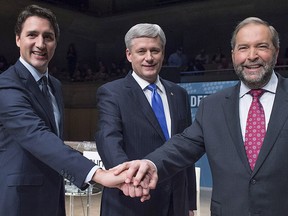 Liberal Leader Justin Trudeau, left to right, Conservative Leader Stephen Harper and NDP Leader Thomas Mulcair join hands prior to the Munk Debate on foreign affairs, in Toronto, on Monday, Sept. 28, 2015. REUTERS/Nathan Denette/Pool