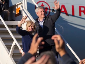 Conservative Leader Stephen Harper and his wife Laureen Harper wave to supporters as they enter the plane after a campaign stop in Edmonton, Alta., on Wednesday, October 7, 2015. THE CANADIAN PRESS/Jason Franson