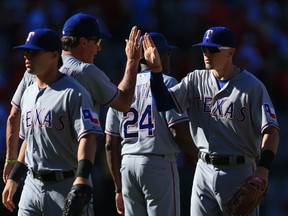 Ryan Rua of the Texas Rangers high fives batting coach Dave Magadan. (Victor Decolongon/AFP)