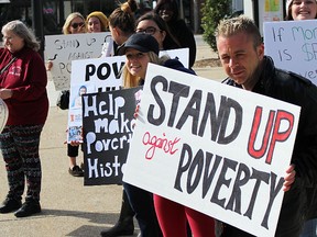 Rally-goers gather at the steps of city hall in Sarnia for the community's annual Stand up Against Poverty rally Friday. Speakers were calling on federal parties for a national housing policy, and for voters to keep poverty in mind when they cast their ballots Monday. (Tyler Kula/Sarnia Observer/Postmedia Network)
