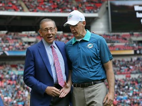Miami Dolphins owner Stephen Ross, left, and Miami Dolphins head coach Joe Philbin shakes hands during warm-up before the NFL football game between the New York Jets and the Miami Dolphins and at Wembley stadium in London, Sunday, Oct. 4, 2015. (AP Photo/Tim Ireland)