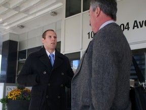 Edmonton Police Const. Nathan Downing speaks with his lawyer Bill Newton outside of the CN Tower 10004-104 Ave, in Edmonton, AB on Friday, October 16, 2015. Downing is facing one count of unlawful and unnecessary exercise of authority, and one count of discreditable conduct after a suspect carrying three ounces of marijuana broke his ankle during a police chase in 2014. TREVOR ROBB/Postmedia Network