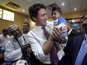 Liberal leader Justin Trudeau holds a baby during a campaign stop in Brampton, Ontario, October 16, 2015. (REUTERS/Chris Wattie)