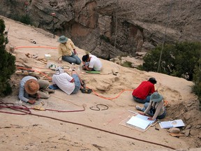 In this undated photo provided by Brigham Young University on Oct. 16, 2015, paleontologists work at a site where a pterosaur, which would have been the largest flying reptile of the time some 210 million years ago, was found in 2009, in Dinosaur National Monument near the town of Jensen in northeastern Utah. Paleontologists have discovered a cliff brimming with fossils that offers a rare glimpse of desert life in western North America early in the age of dinosaurs. (Brooks Britt/Brigham Young University via AP)