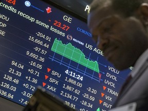 A screen displays the Dow Jones Industrial Average as a trader passes by on the floor after the closing bell at the New York Stock Exchange August 25, 2015. (REUTERS/Brendan McDermid)